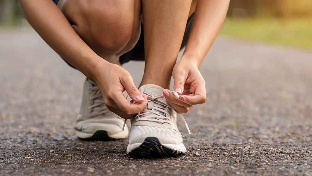 Gros plan réaliste de chaussures de running lacées sur chemin avant une sortie sans texte ni marque visible