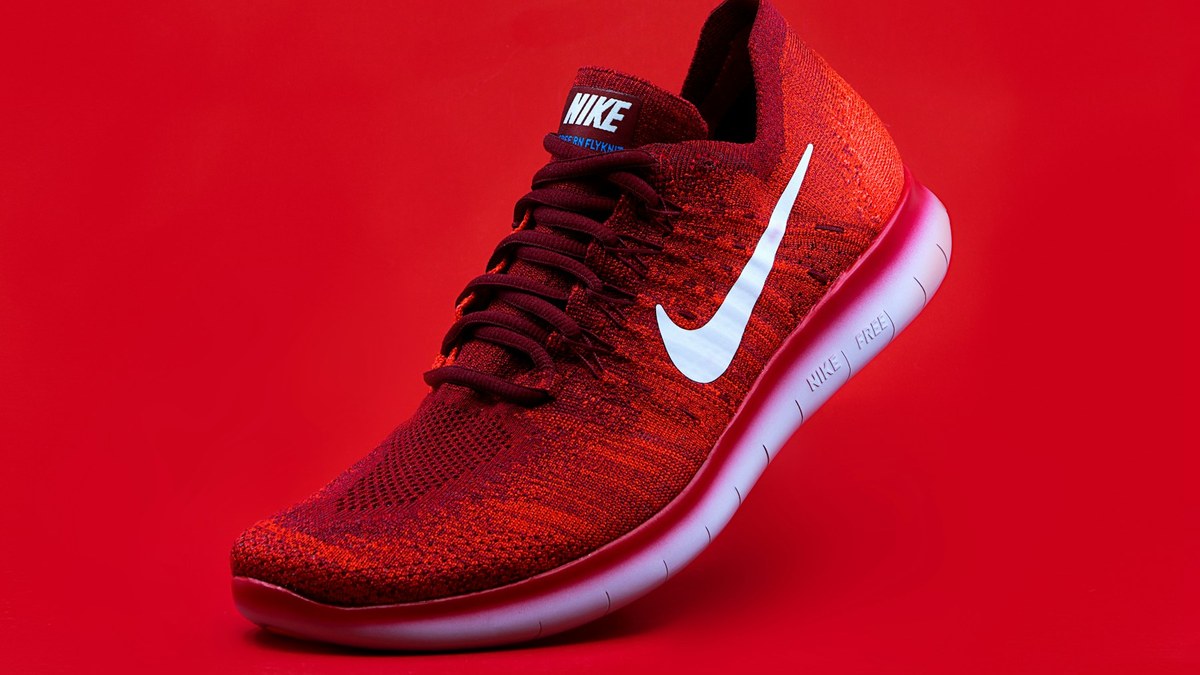 Paire de chaussures de running posée sur un chemin stabilisé près d’une route de parc