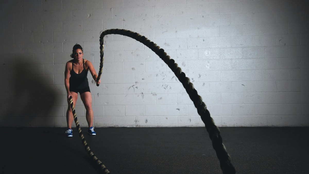 Sportive réalisant une fente arrière contrôlée dans une salle de sport lumineuse