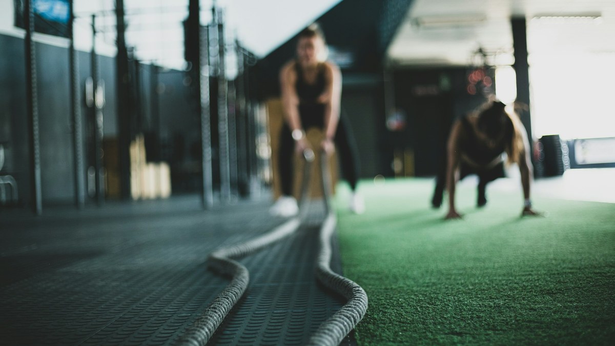 Sportive tenant un haltère en goblet squat dans une salle de sport lumineuse