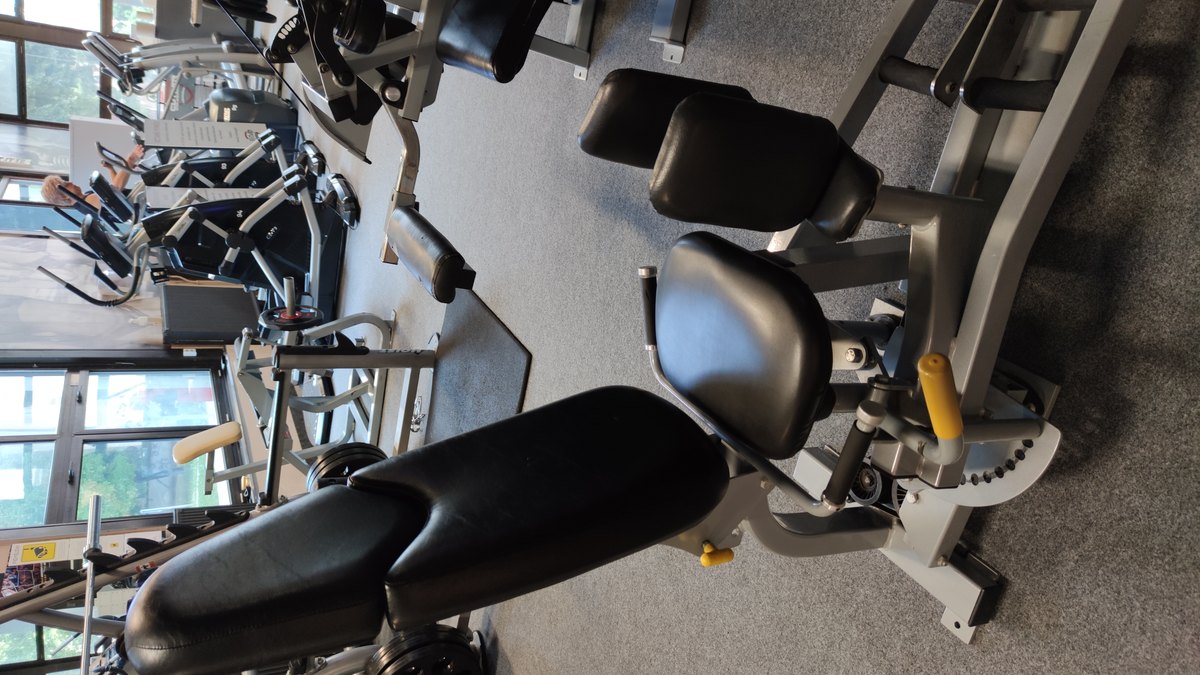Sportive utilisant une machine abducteurs en salle de sport sans texte ni logo