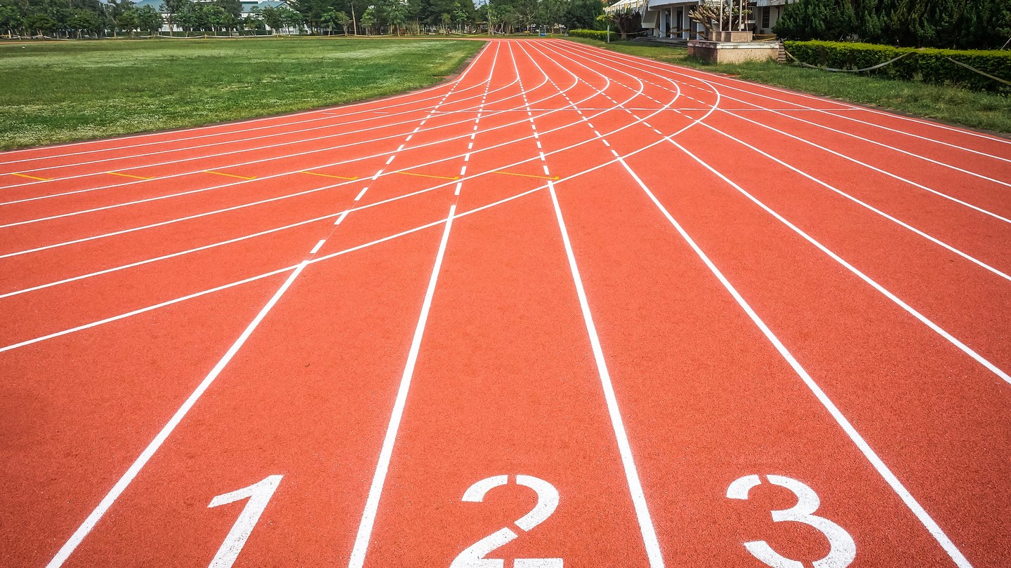 Coureur nouant des chaussures de running stables sur piste extérieure